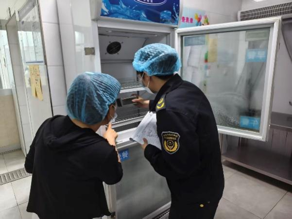 执法人员检查幼儿园食堂