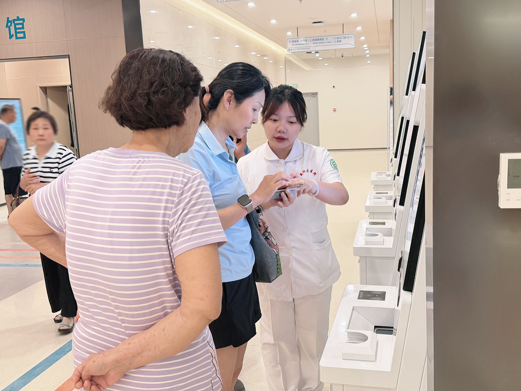 工作人员指导群众操作自助设备